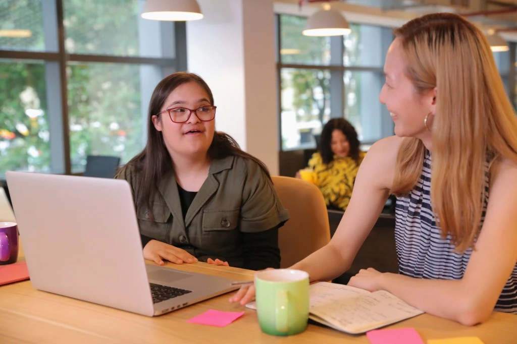 Disabled woman with down syndrome talking with support worker